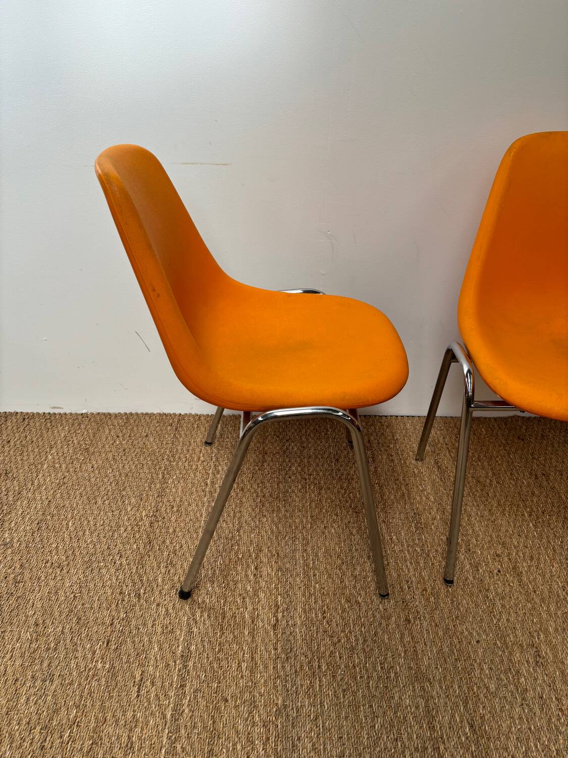 Two orange plastic pollak chairs at Orly airport