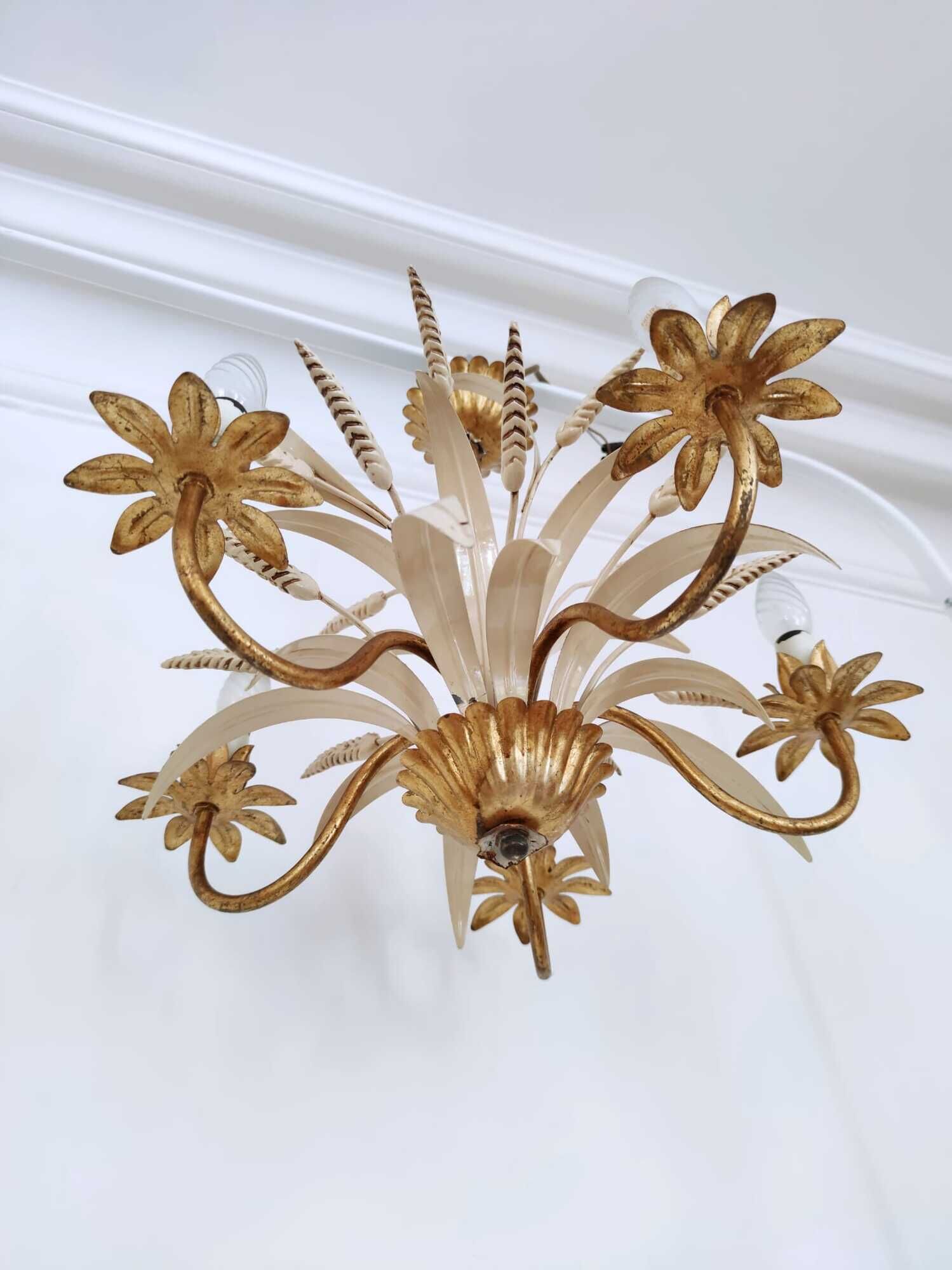 Vintage wrought iron chandelier decorated with golden and beige reeds