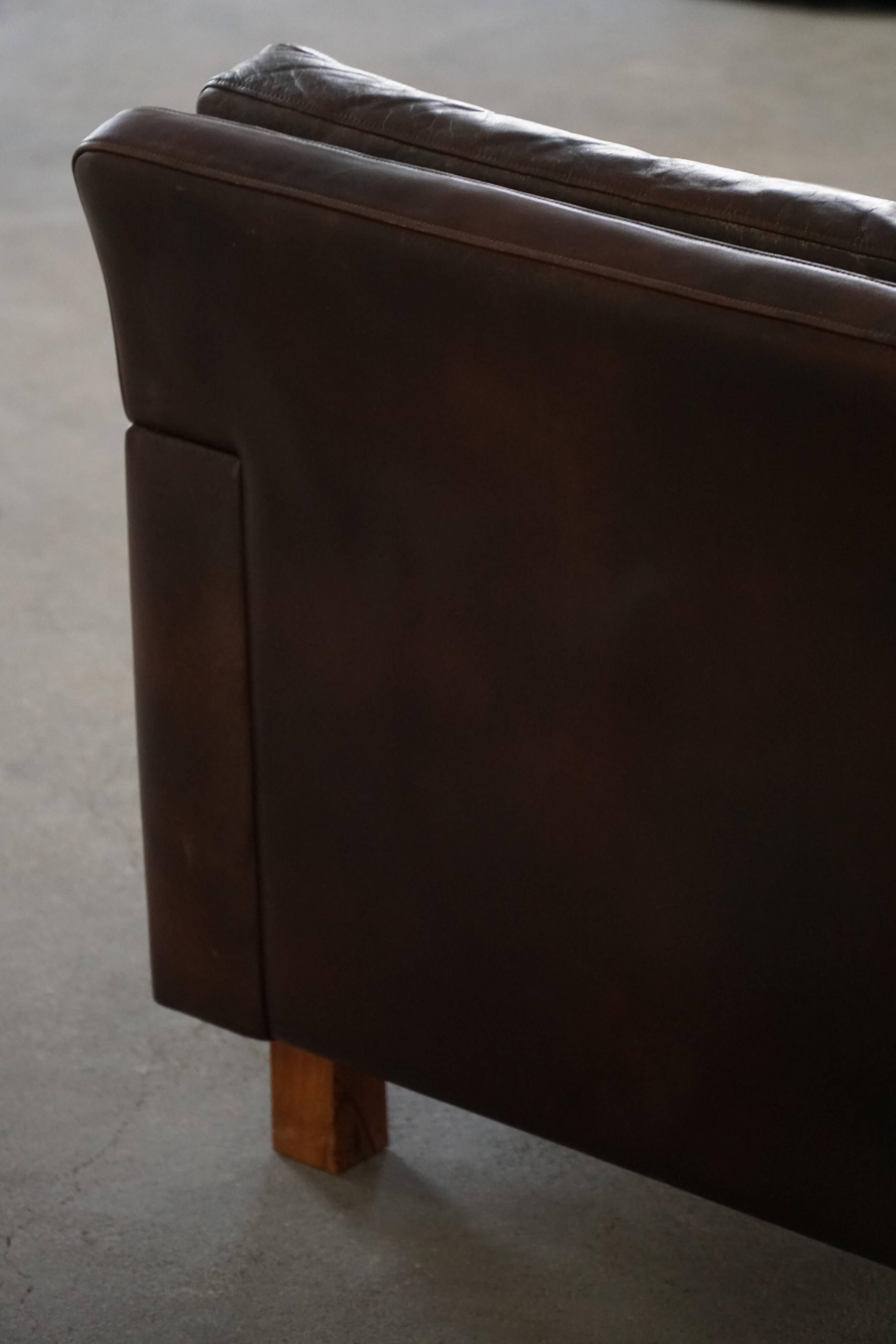 Pair of modern Danish lounge chairs in dark brown leather and rosewood, 1960s.