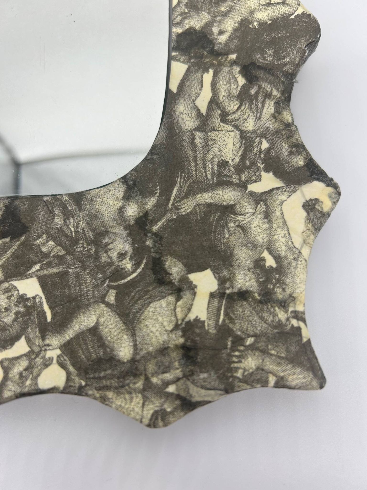 Free-form mirror decorated with cherubs.