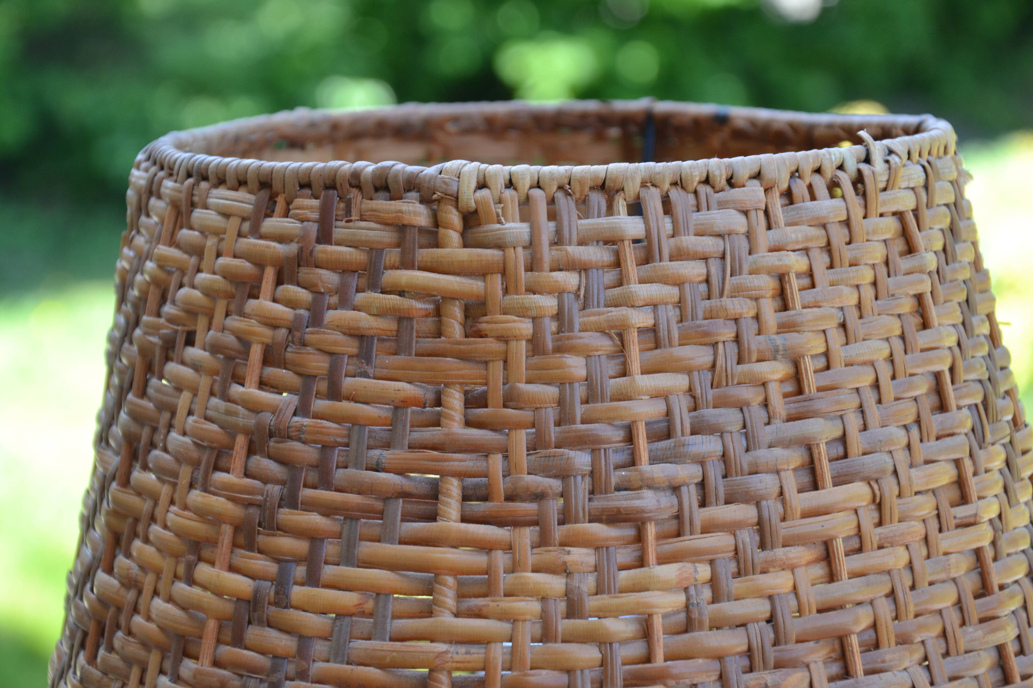 Large wooden lamp with a woven rattan shade.