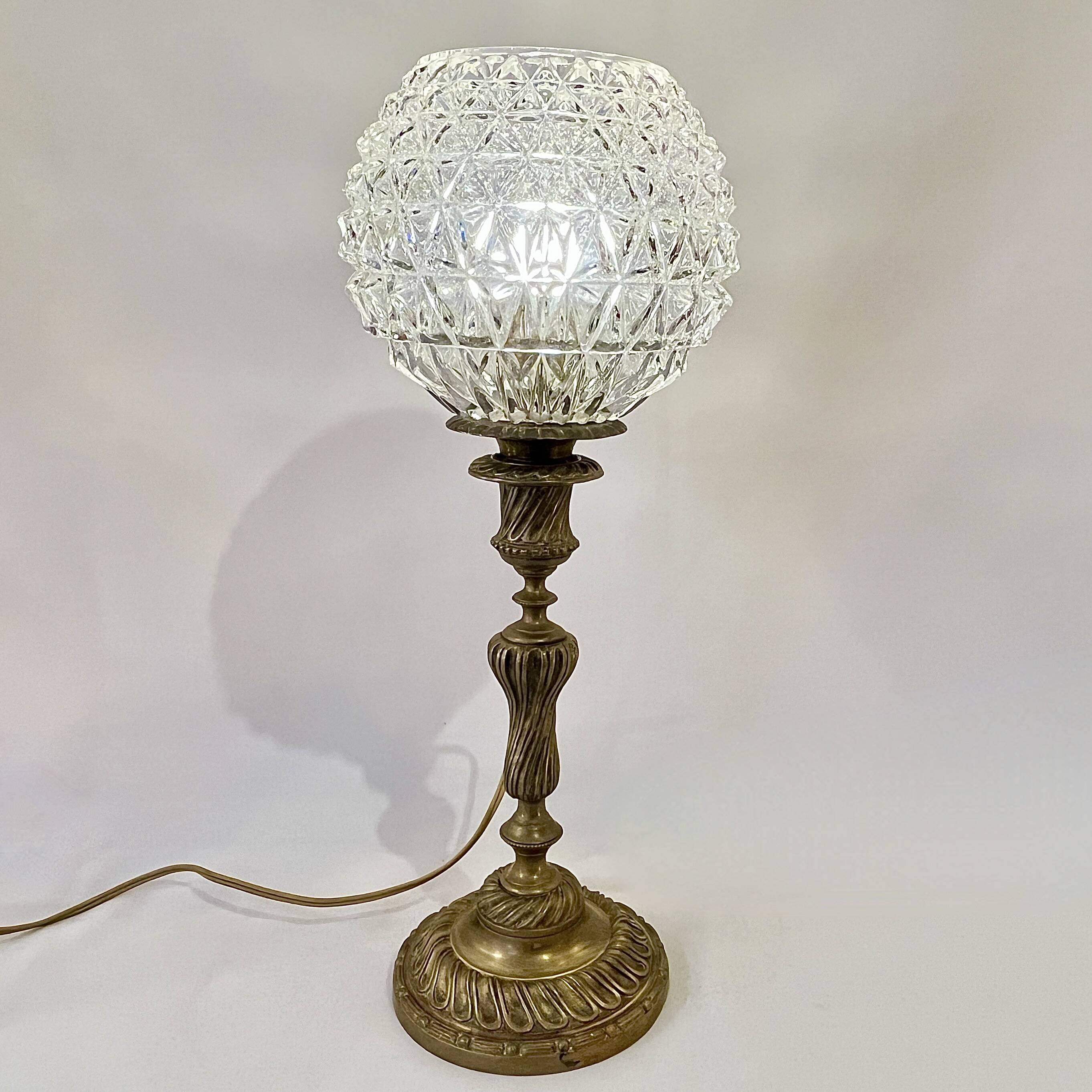 Antique brass foot lamp with glass globe and diamond point.