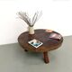Brutalist coffee table in solid teak, monolithic slab, tripod base.