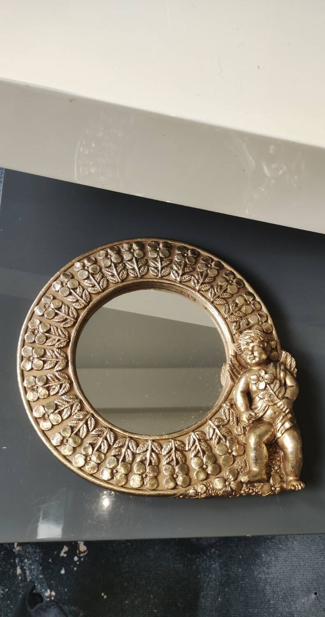 Shabby Chic round mirror. Putti/Cherub decor. Floral motifs. Dimensions: 20 x 20 cm.