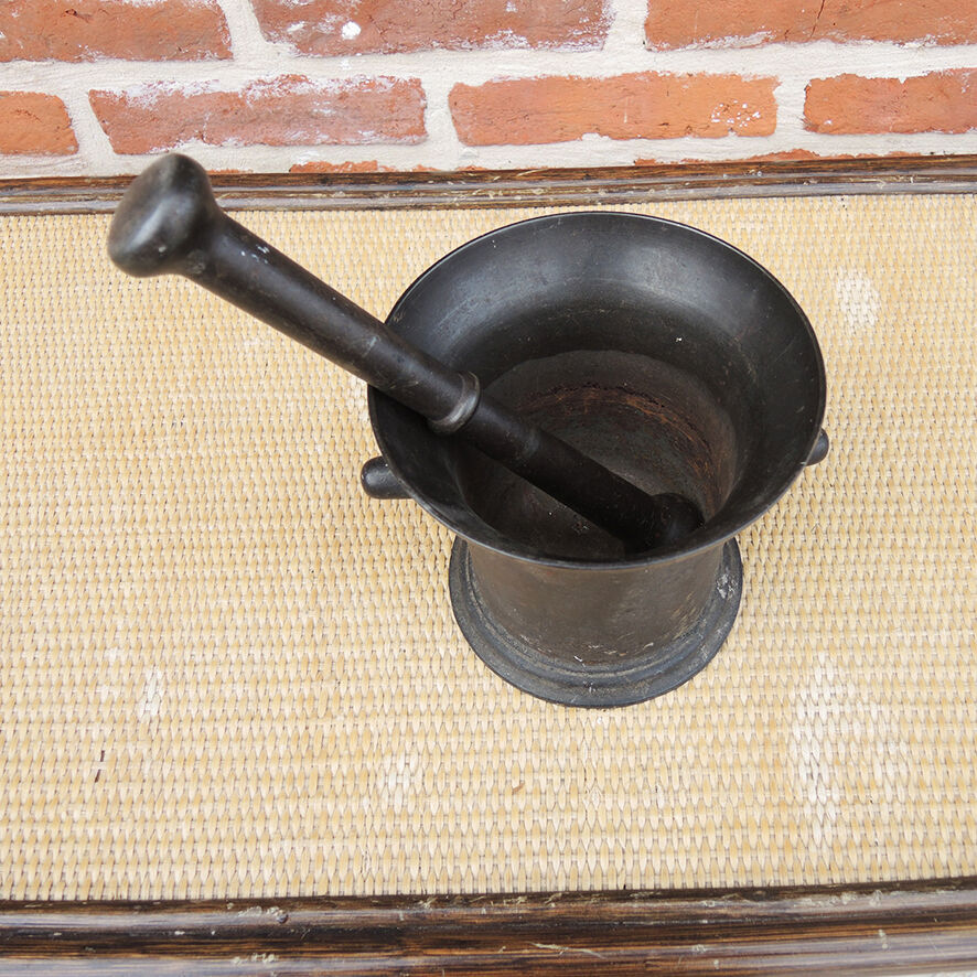 Ancient large mortar and pestle of a black cast iron apothecary.