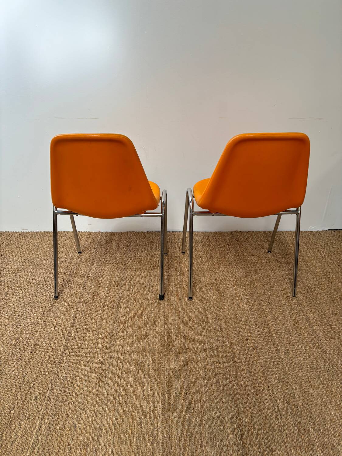 Two orange plastic pollak chairs at Orly airport