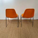 Two orange plastic pollak chairs at Orly airport