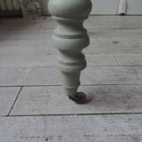Walnut table with raised flaps, base on verdigris casters.