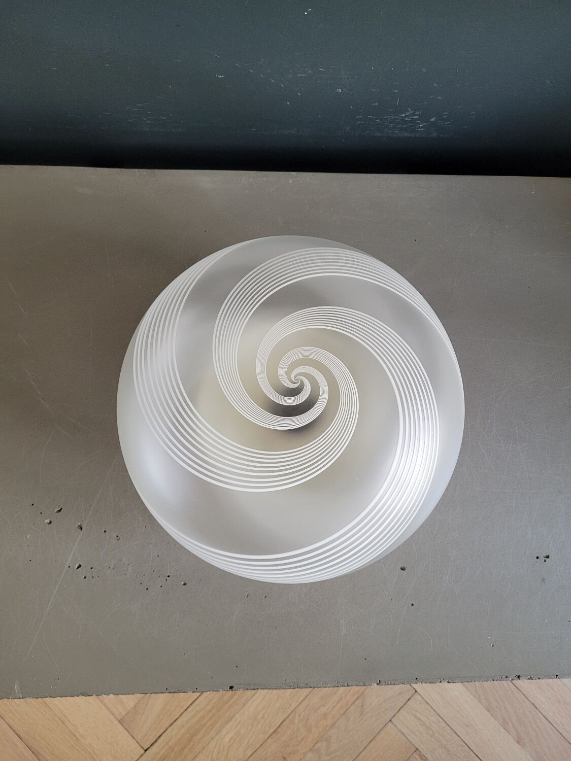 Frosted glass globe ceiling light with spiral patterns.