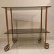 Vintage rolling dessert trolley with smoked glass trays and a golden base.