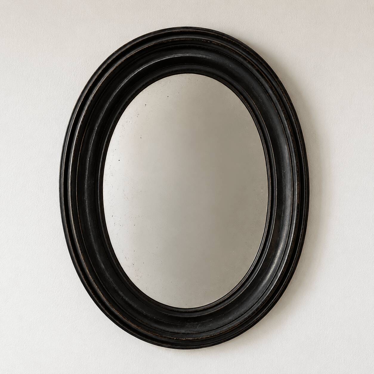 Antique oval mirror in patinated black wood