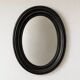 Antique oval mirror in patinated black wood
