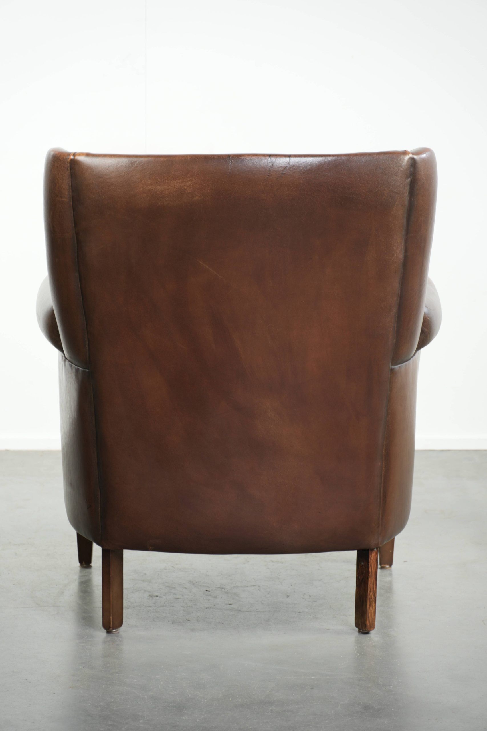 Subtle sheepskin wingback armchair with a deep cognac colour