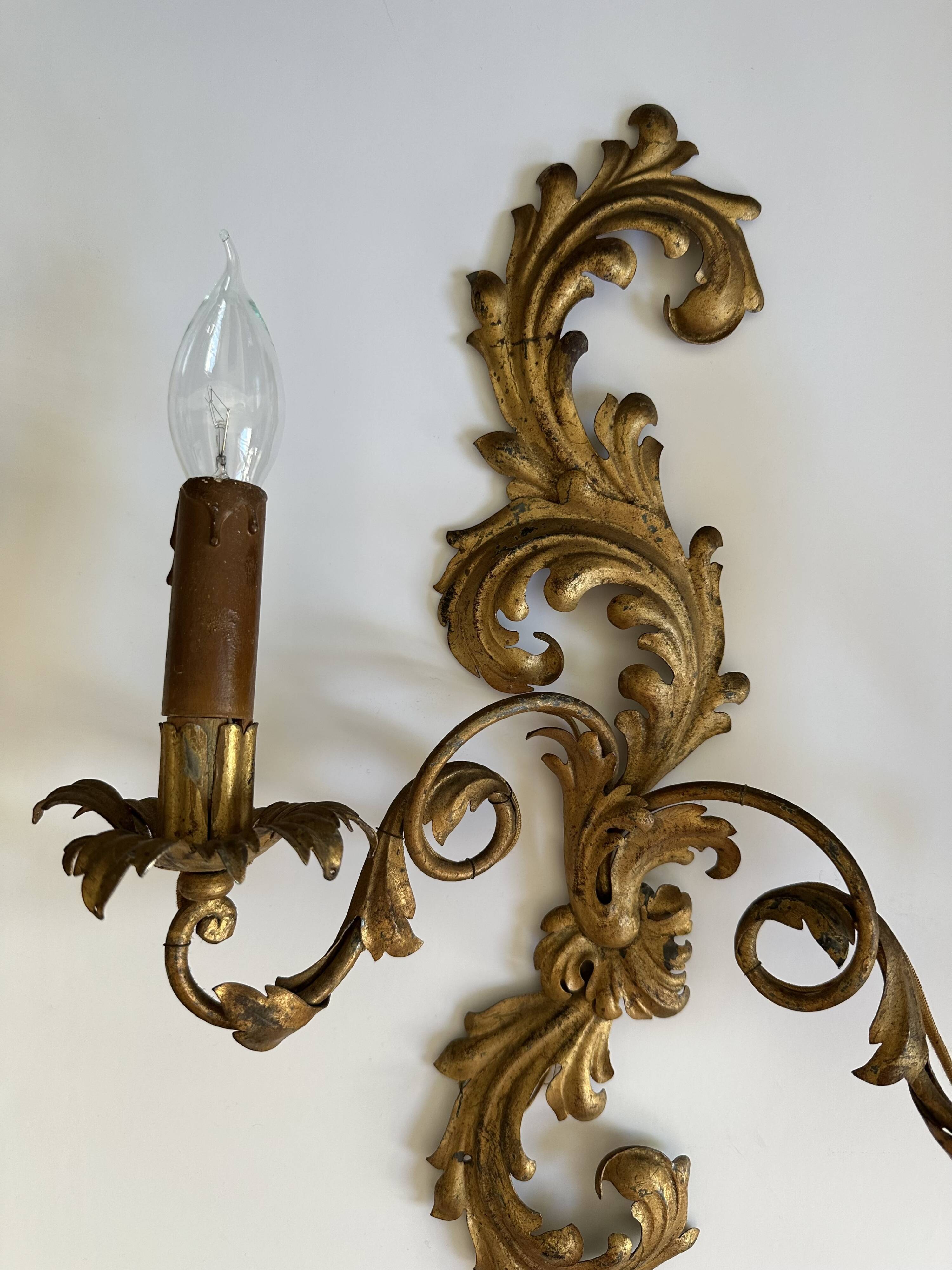Pair of Italian Hollywood Regency wall lights in iron and gilded sheet metal.