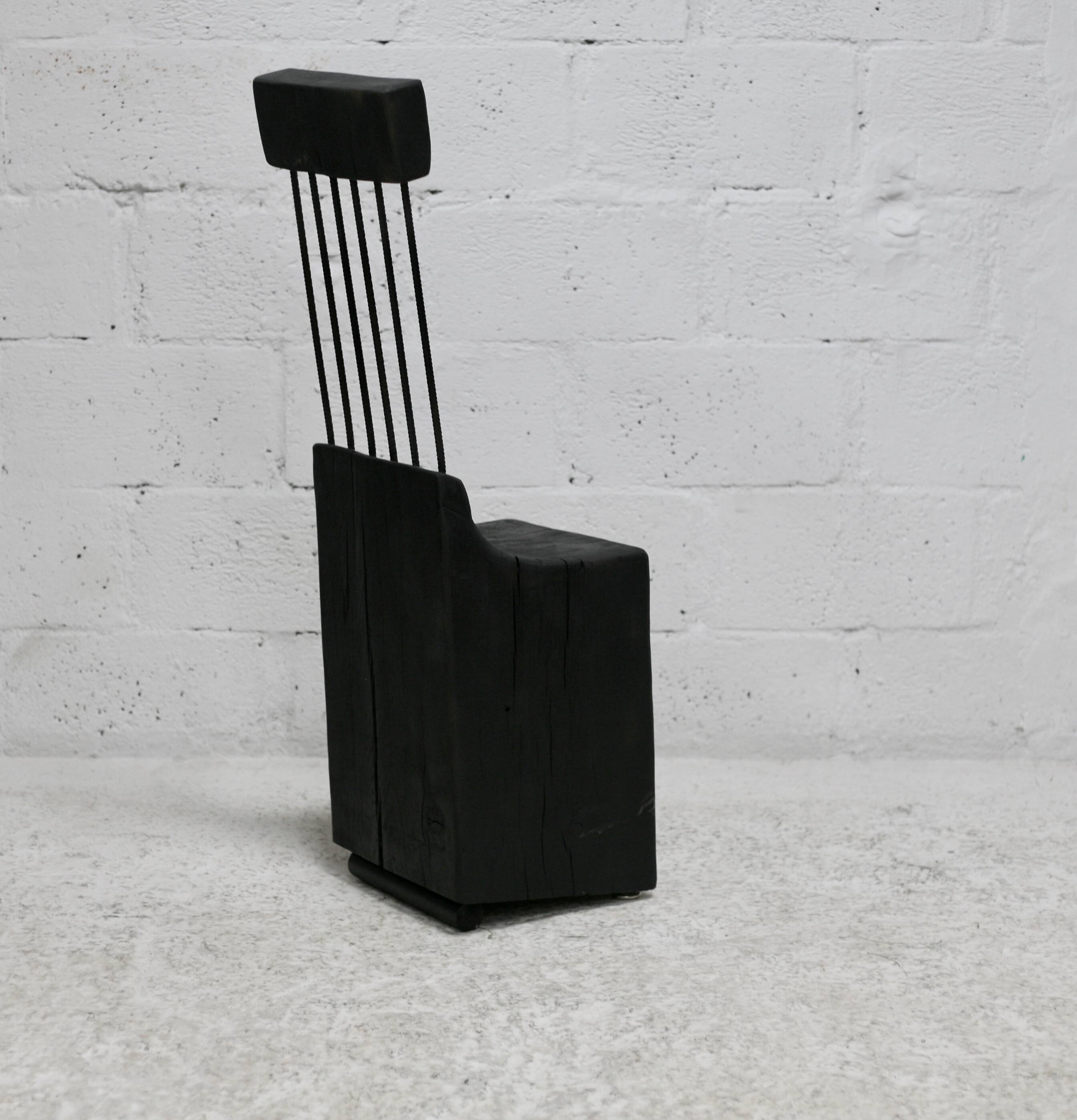 Brutalist chair, black-stained raw wood, steel. Work from the 1970s