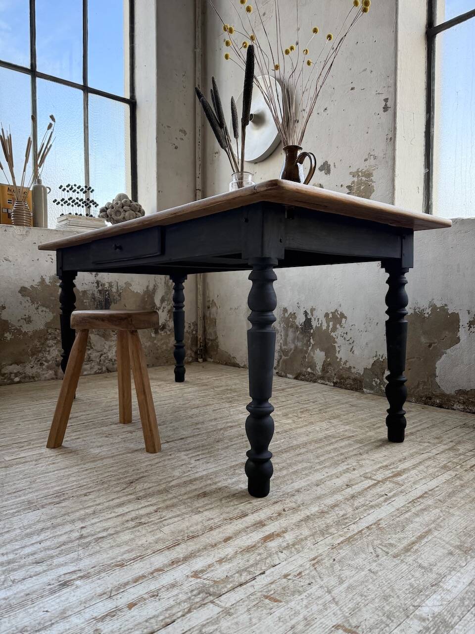 Oak farmhouse table with turned black legs.