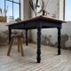 Oak farmhouse table with turned black legs.