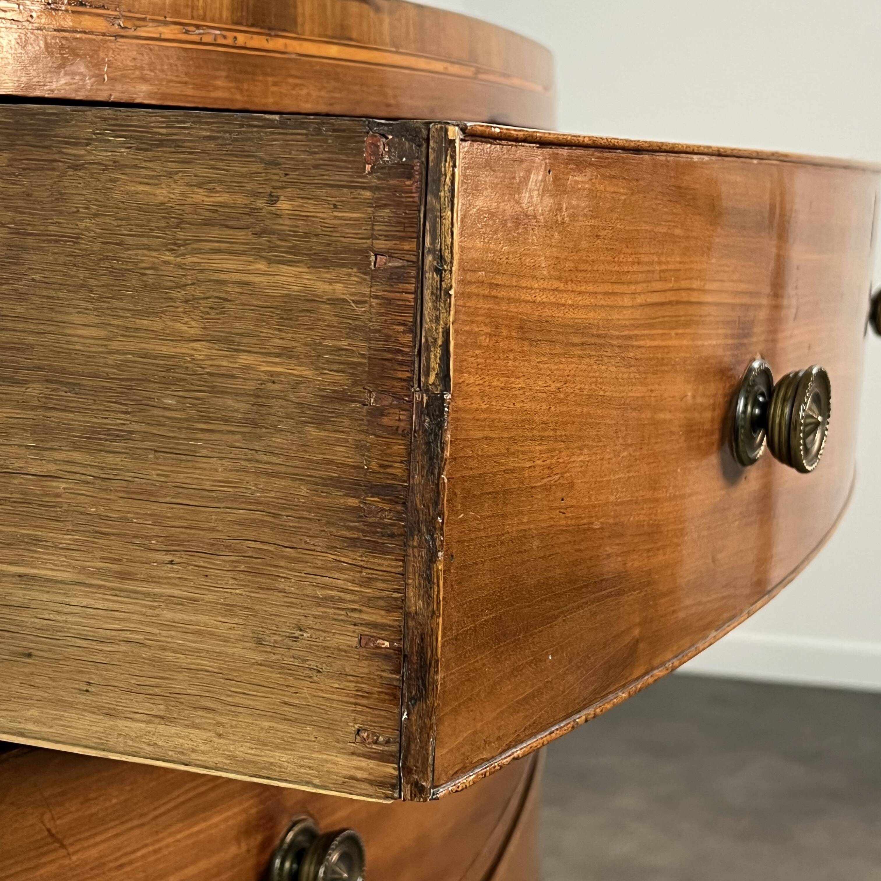English commode from the George III Regency period, bombe shape in mahogany veneer.