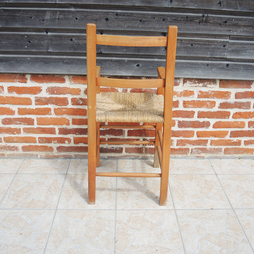 Old wooden high chair for children with straw.