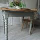 Walnut table with raised flaps, base on verdigris casters.
