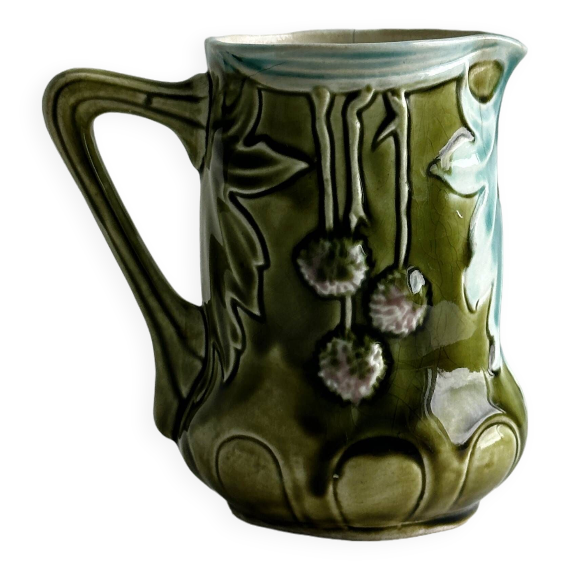 Green slip milk jug with floral patterns.