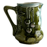 Green slip milk jug with floral patterns.