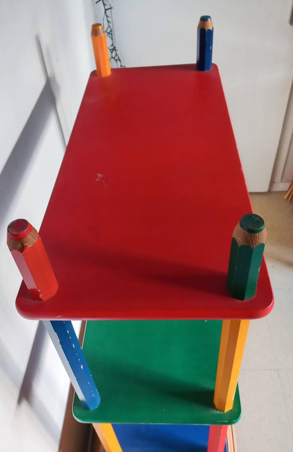 Shelf on legs, library, crayons in 4 colours.