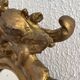 Antique rococo mirror with putti, gilded carved wood and stucco frame, 19th century.