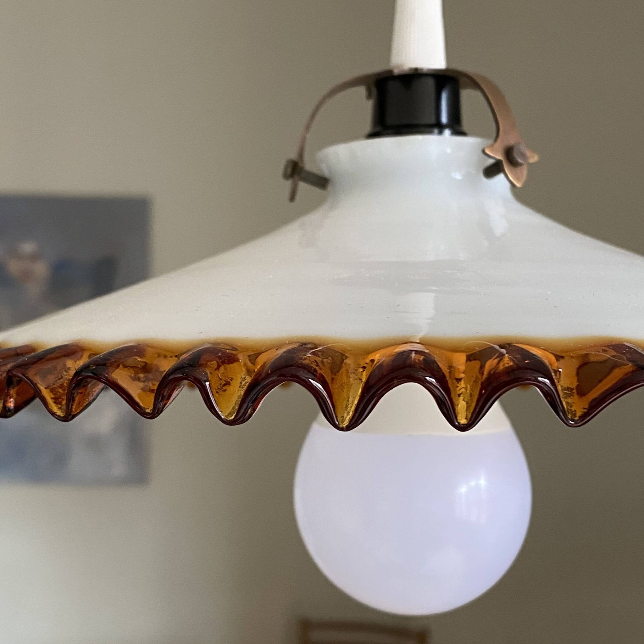 Old pendant light with a white opaline glass shade and a wavy border.