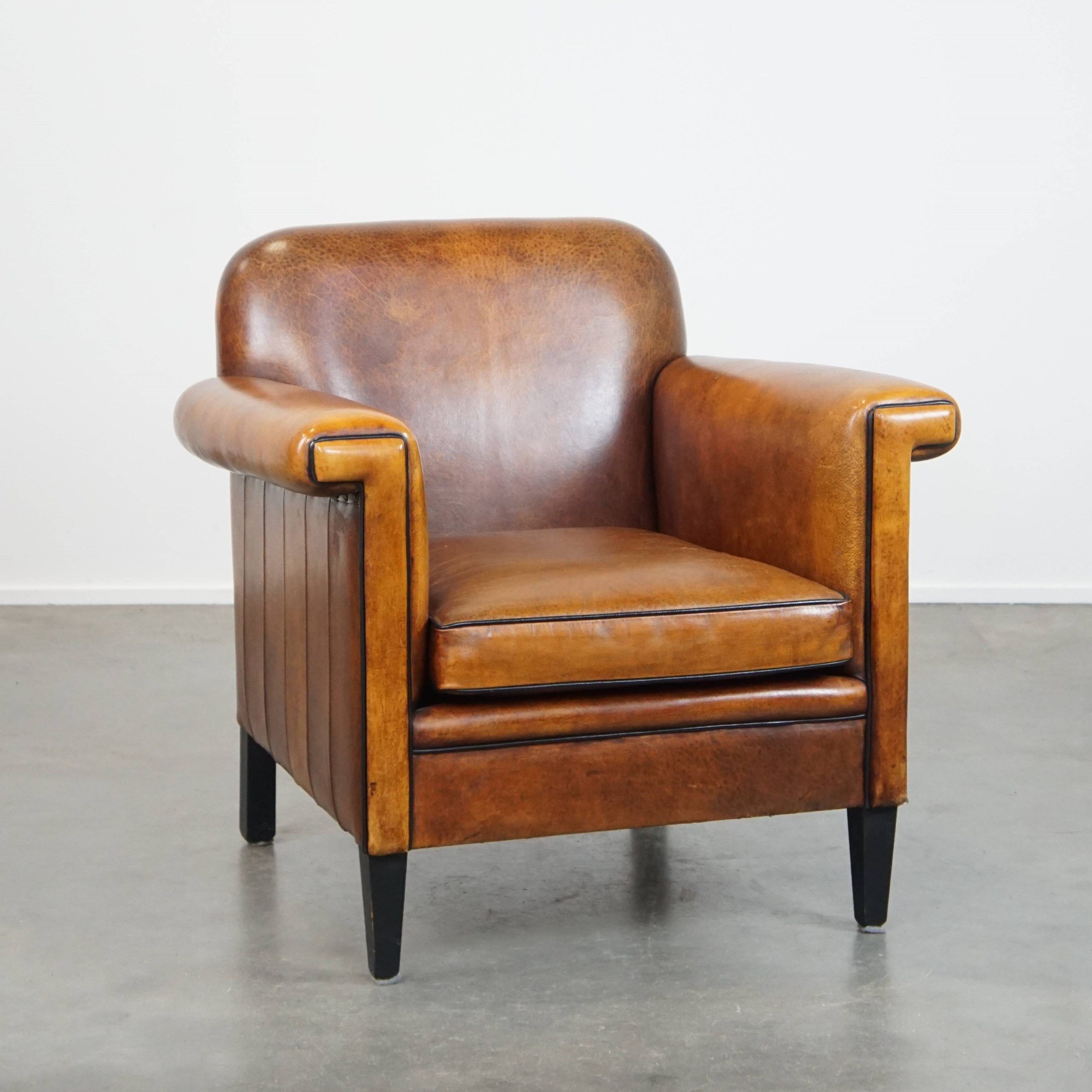 Sheepskin Art Deco design armchair with sleek finish and black piping