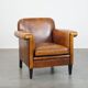Sheepskin Art Deco design armchair with sleek finish and black piping