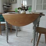Walnut table with raised flaps, base on verdigris casters.