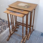Sets of three nesting tables with painted landscape decorations in poplar.