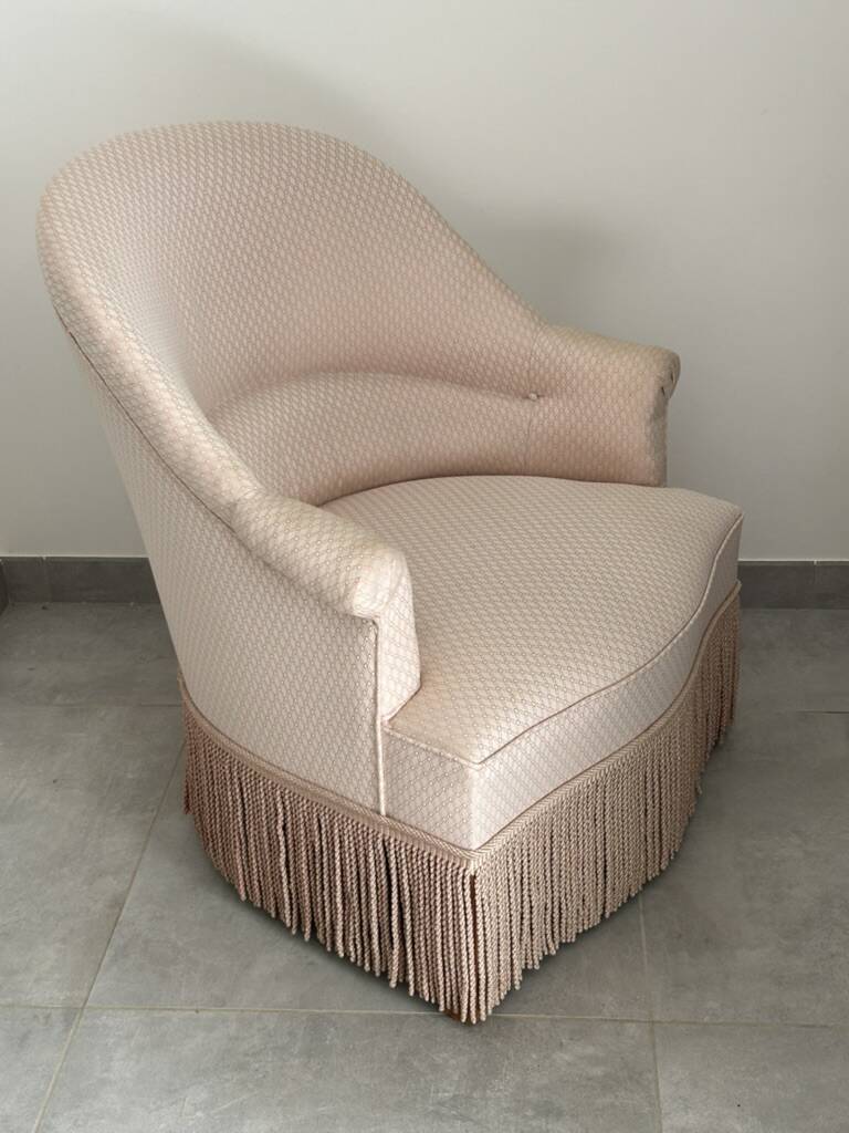 Pink armchair with patterns and fringes.