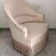 Pink armchair with patterns and fringes.