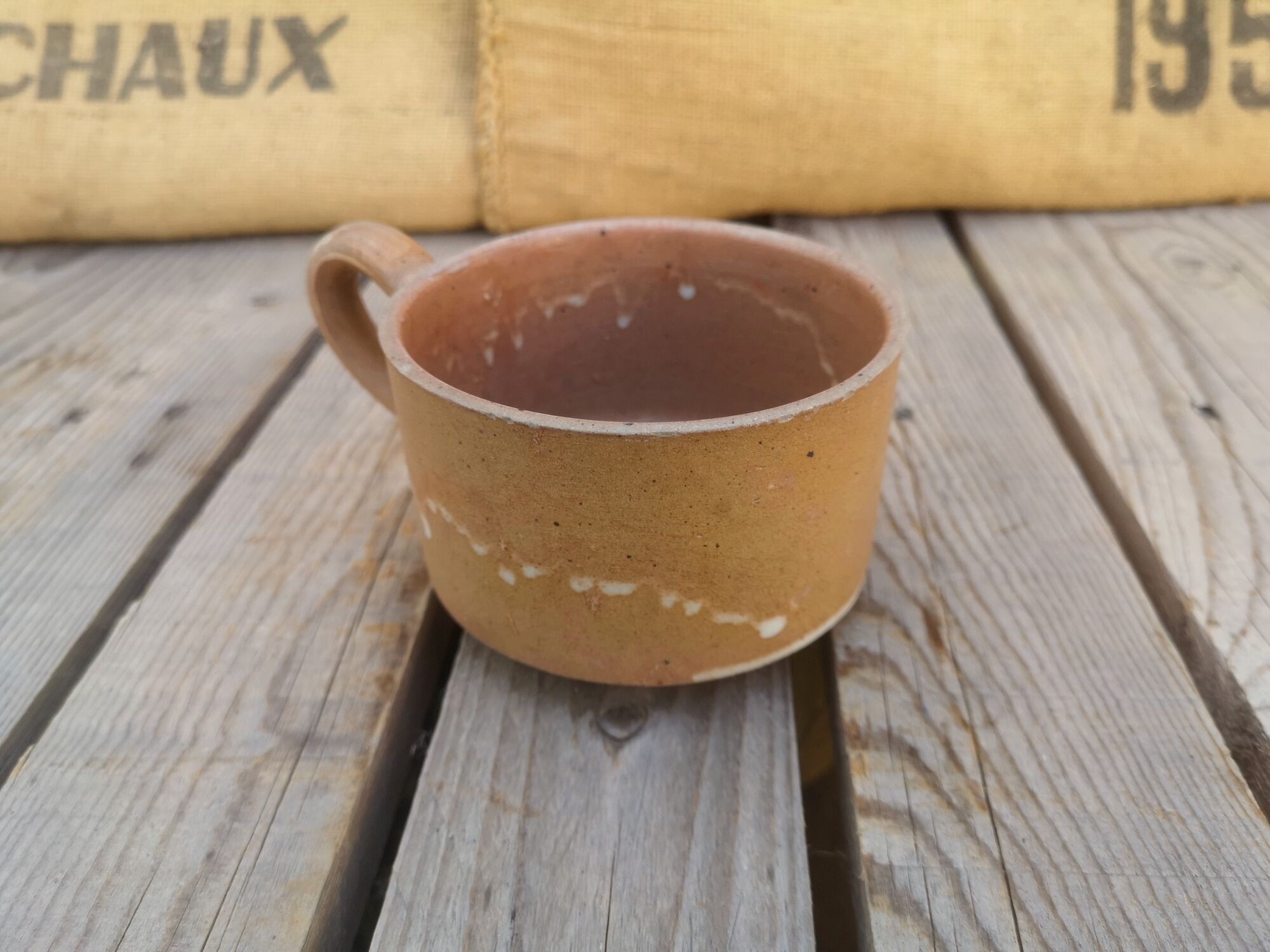 Brown sandstone cup with white spots