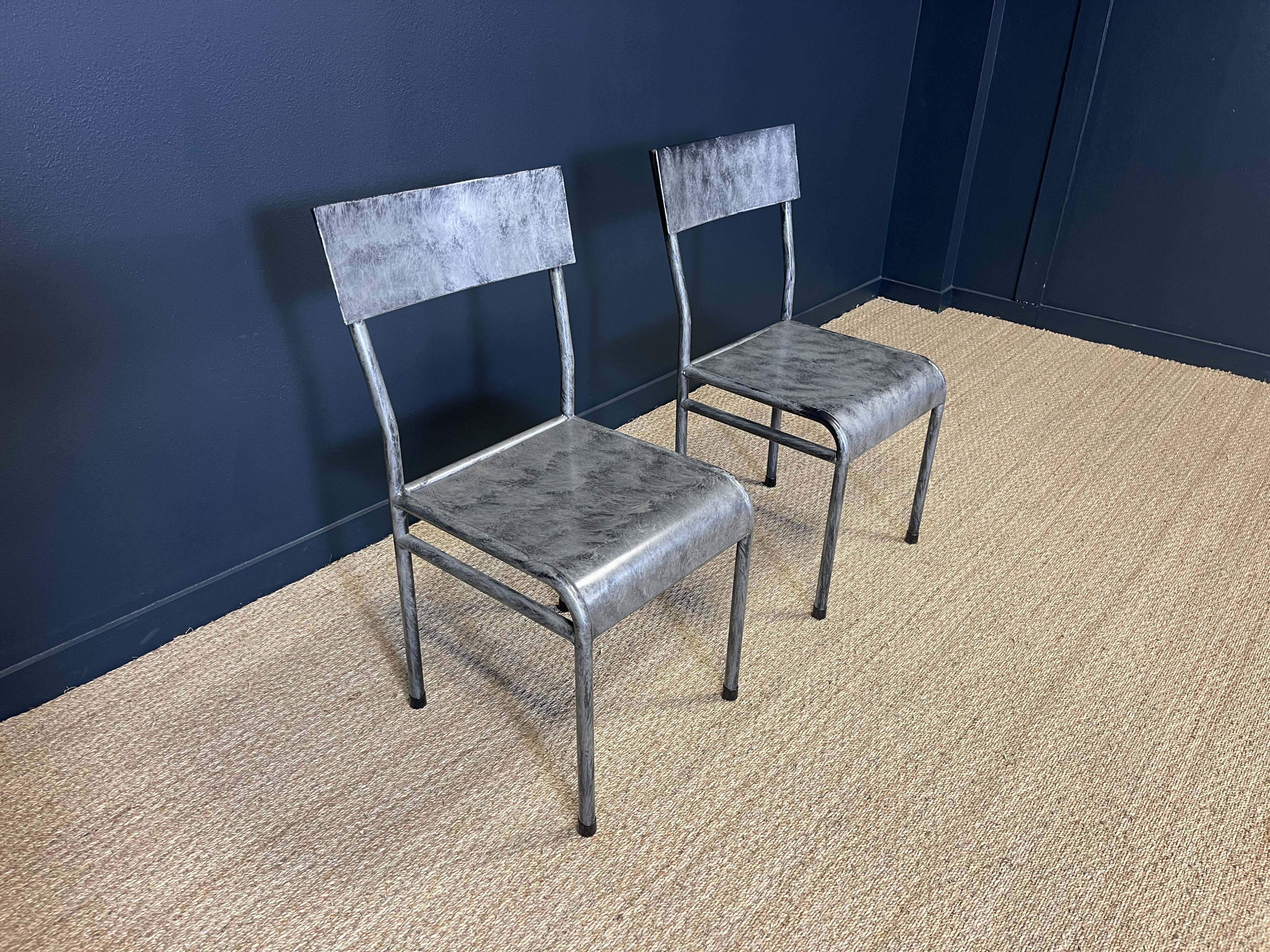 Pair of gray metal industrial chairs