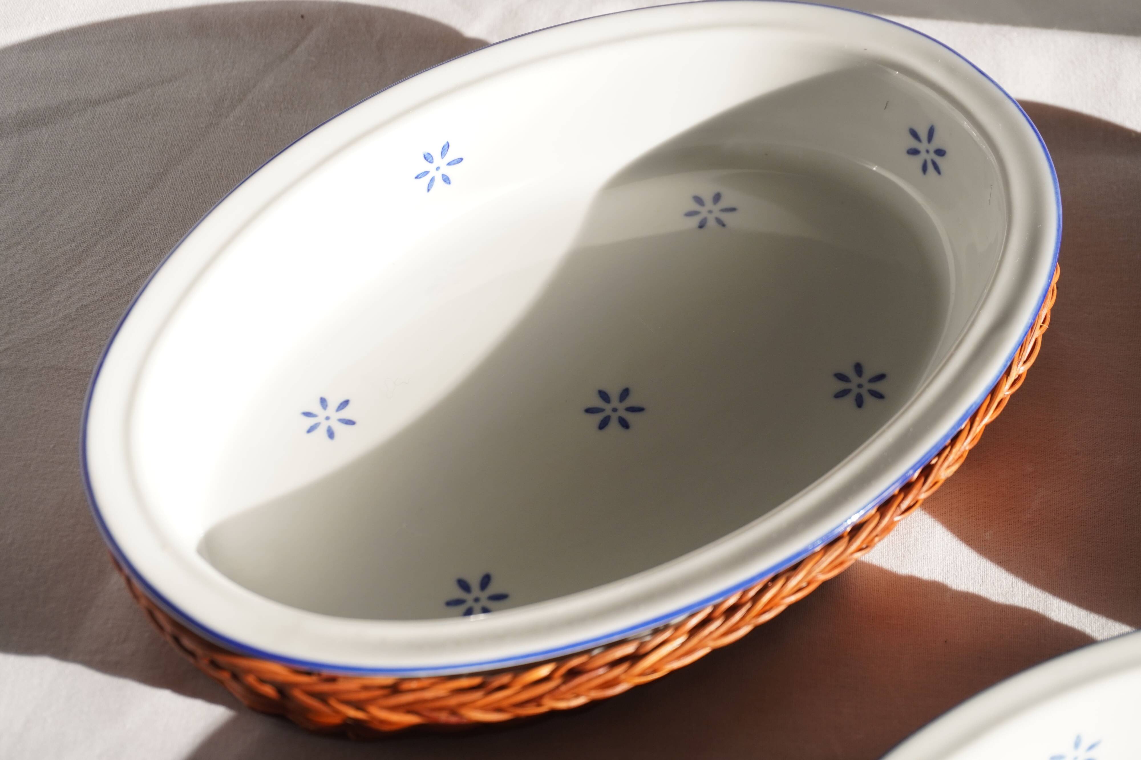 Set of 4 white porcelain dishes with blue decorations and wicker stands