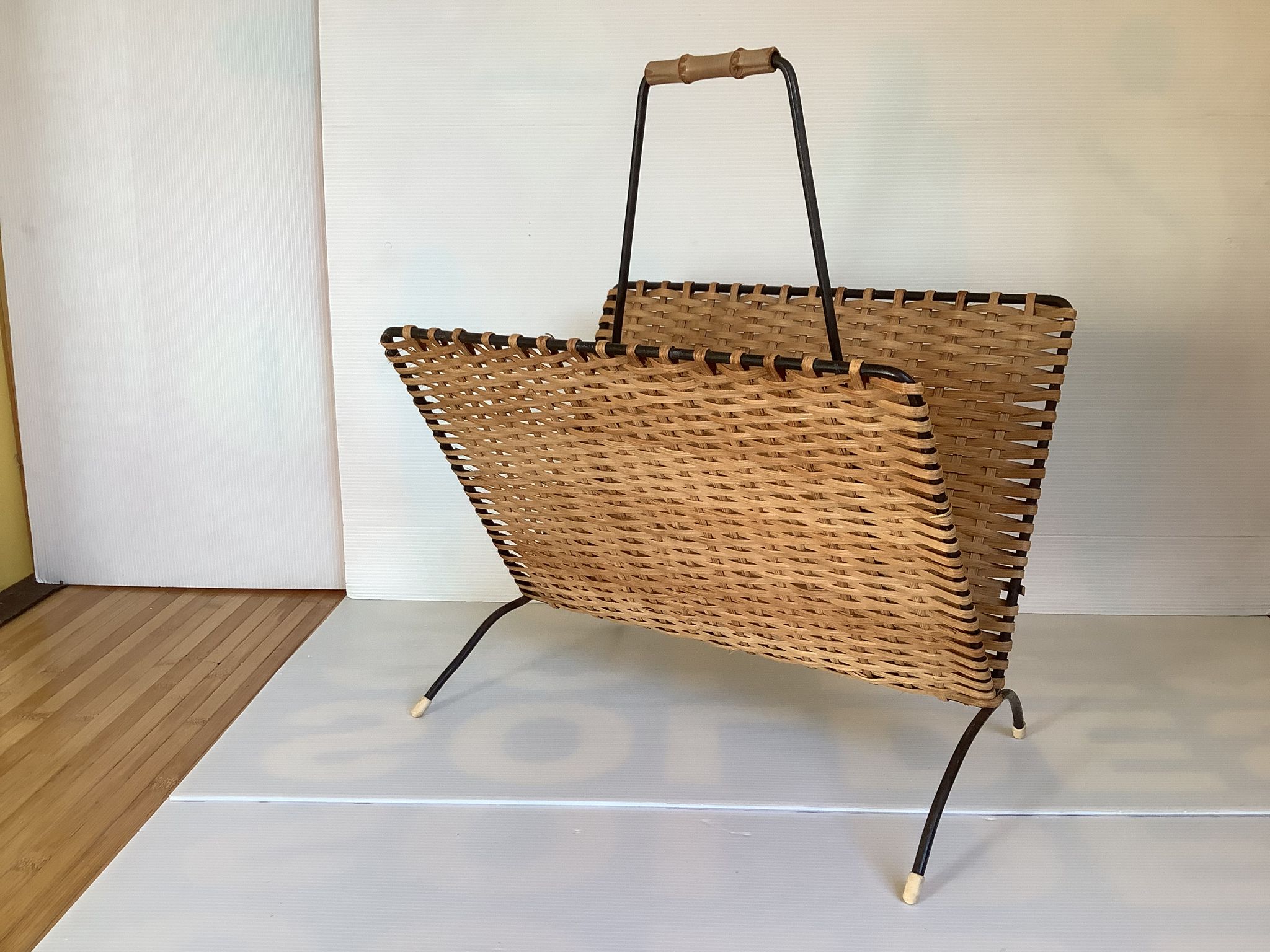 Old magazine rack in straw and black metal