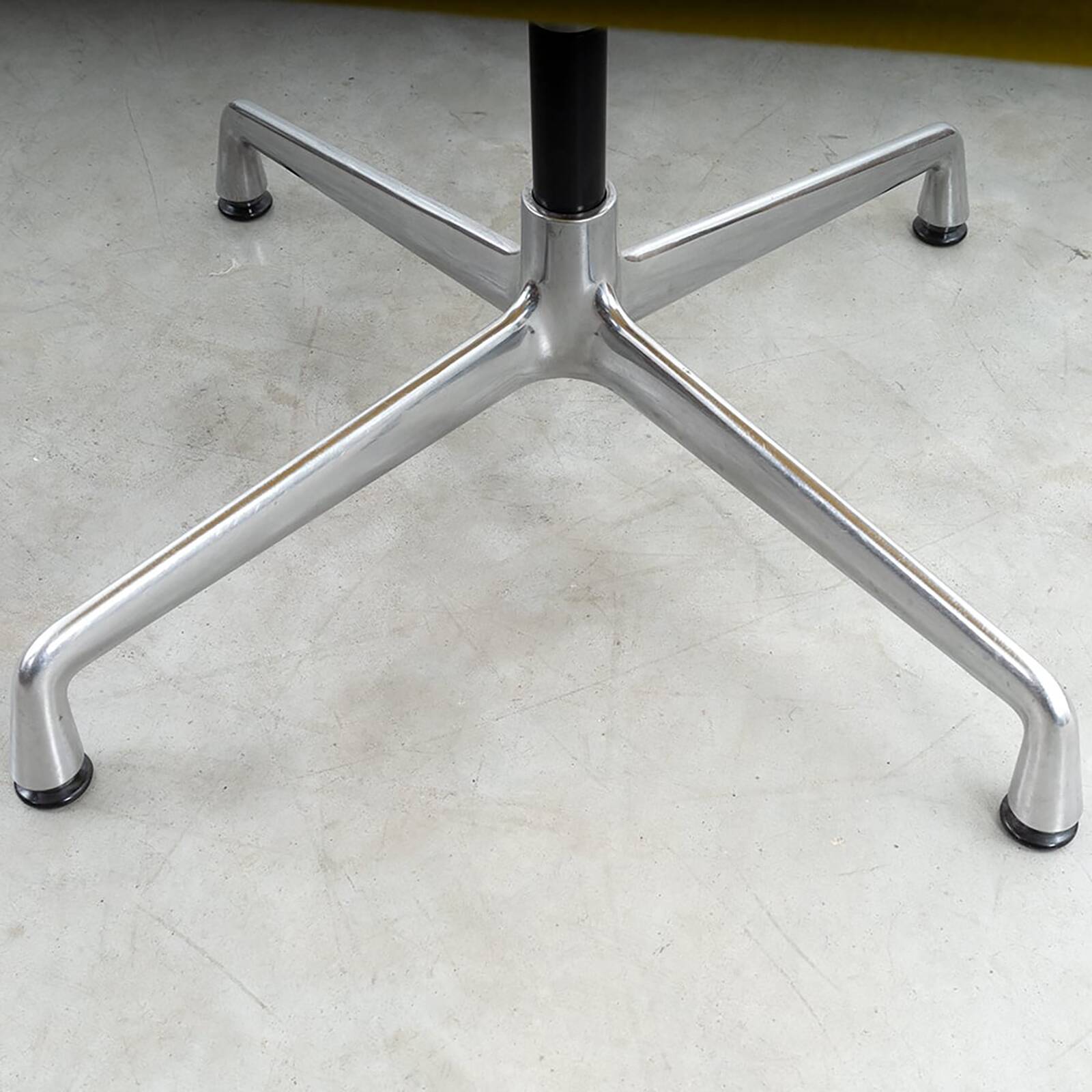 Fauteuil Aluminum Group EA107 de Charles et Ray Eames en tissu jaune.