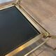 Brass coffee table with a black leather top and golden edges from Maison Jansen.