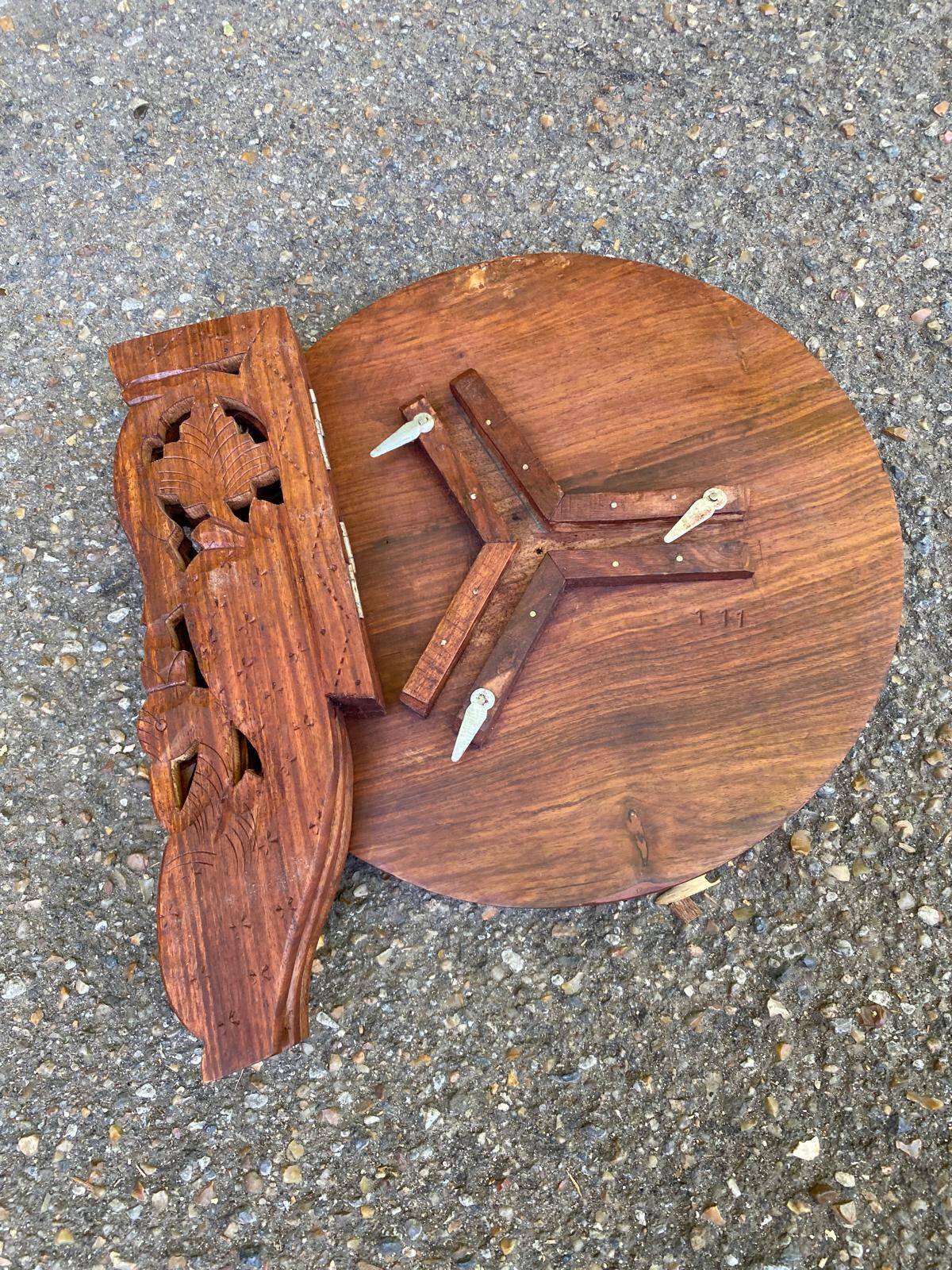 Round folding side table made of carved solid wood.