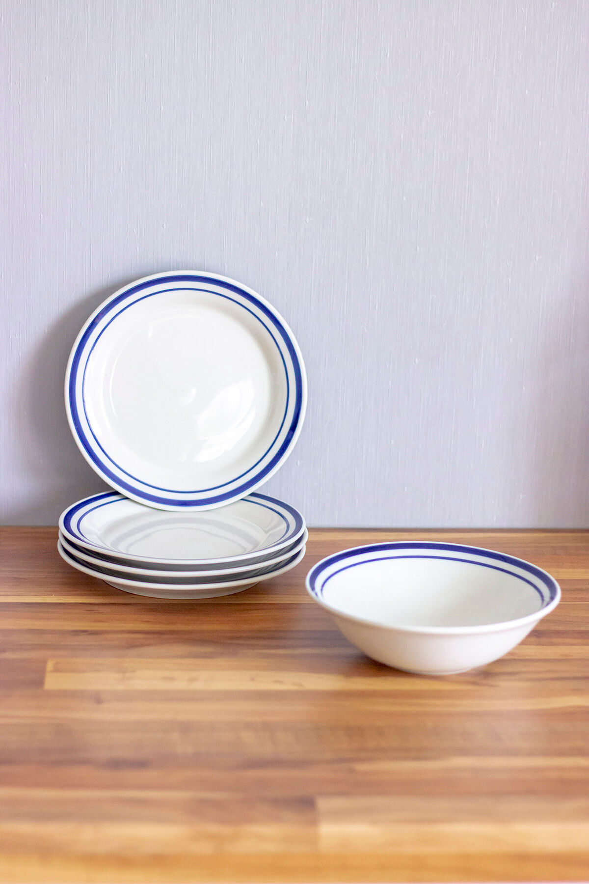 4 blue bordered dessert plates and a matching bowl