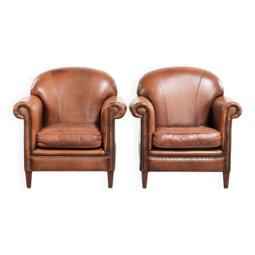 Set of two vintage sheepskin armchairs finished with decorative nails