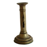 Antique brass candlestick with a push button.