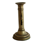 Antique brass candlestick with a push button.