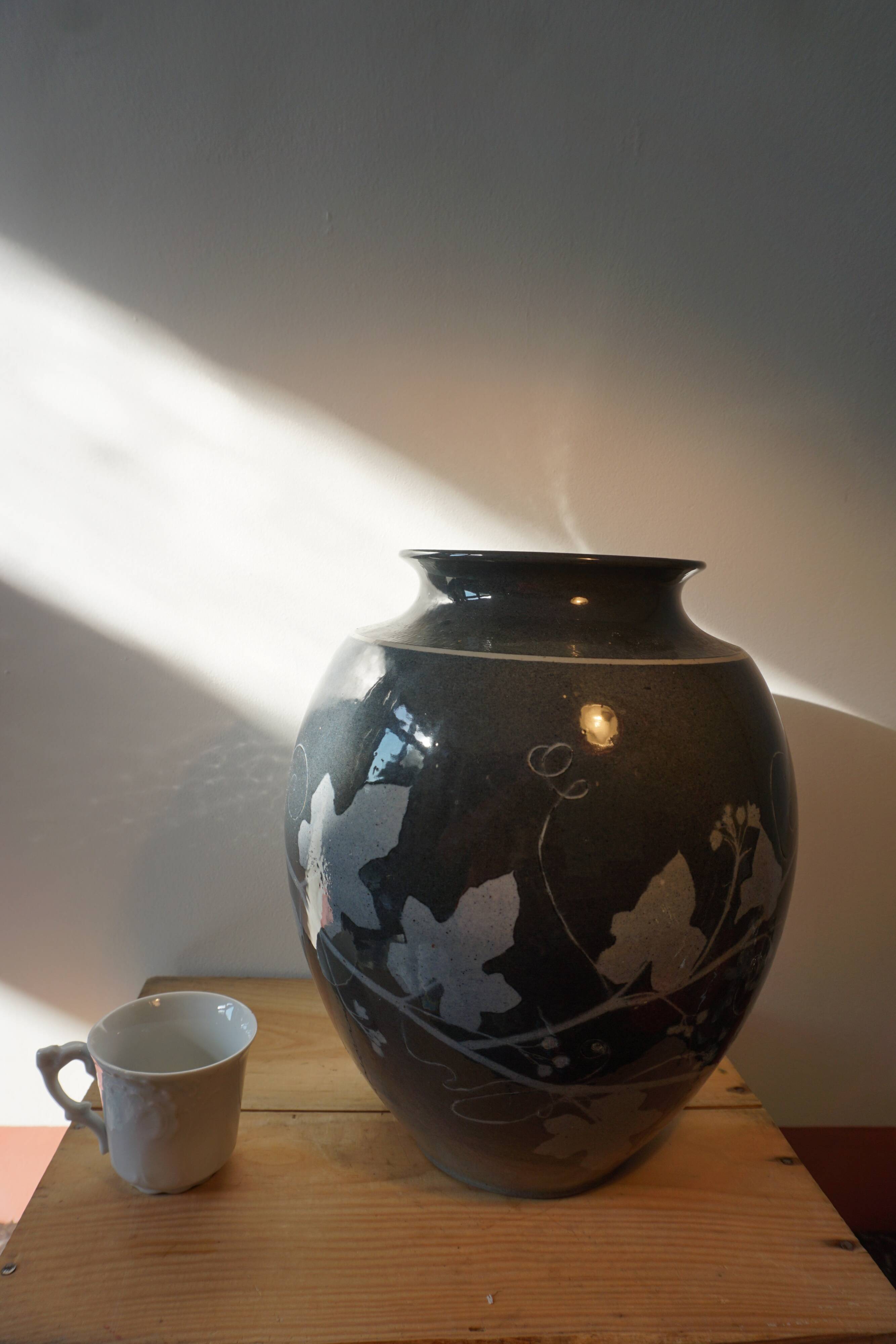 Black vase with plant decoration by Philippe Jacques