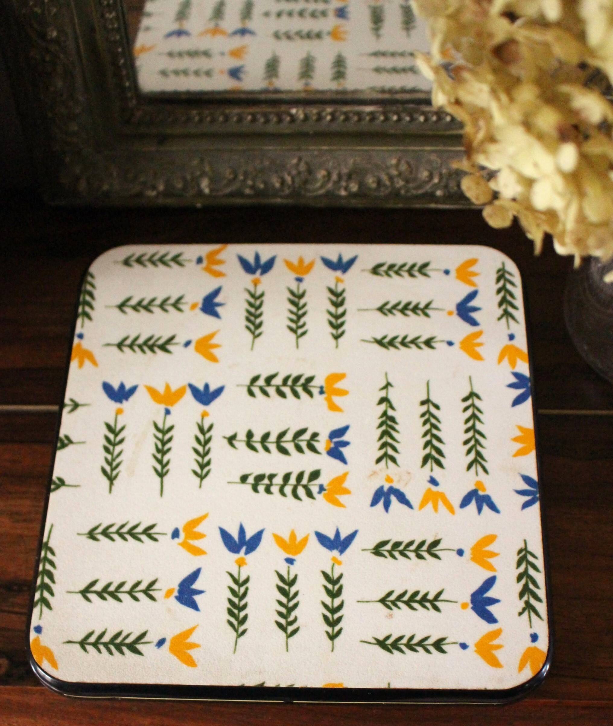 Vintage laminated wooden trivet with yellow, green, and blue flowers