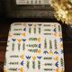 Vintage laminated wooden trivet with yellow, green, and blue flowers