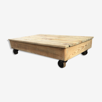 Table basse ancienne estrade d’école en bois sur roulettes métalliques